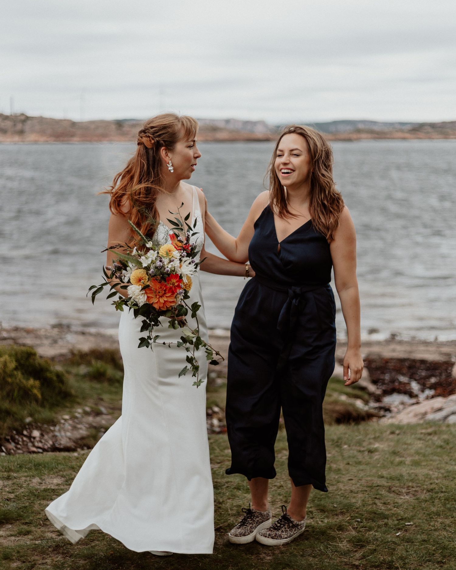 Brud och brudtärna med havet som bakgrund