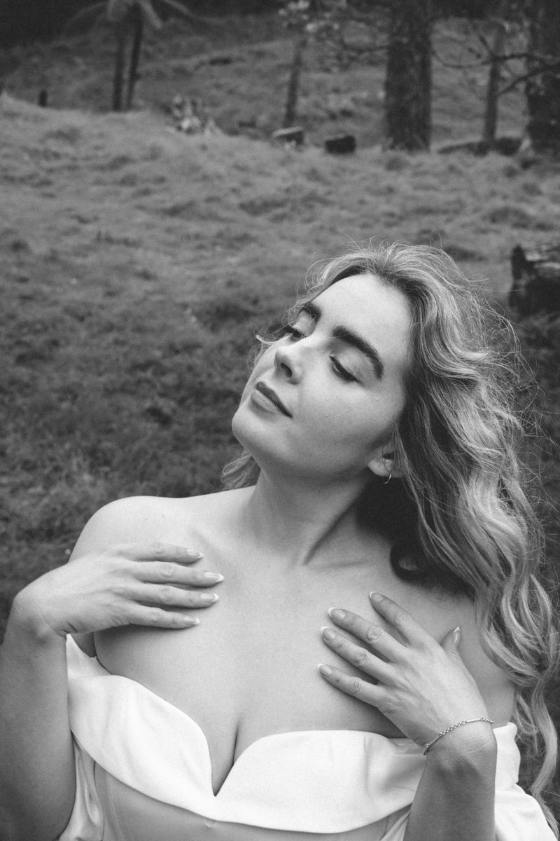 Whimsical fairytale portrait of a maiden in a forest, appreciating herself.