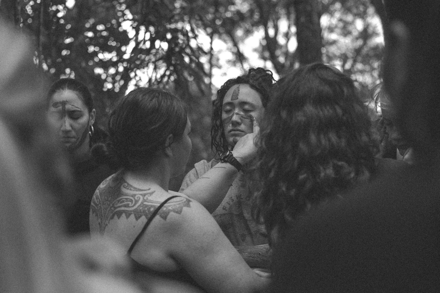 rite of passage mud ceremony, woman getting mud smeared on her cheeks, peacefully and respectfully.