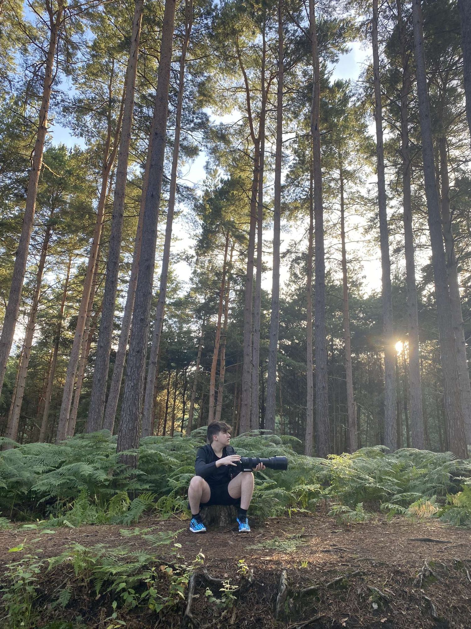 a picture of myself holding a camera looking off to the right in woodlands.