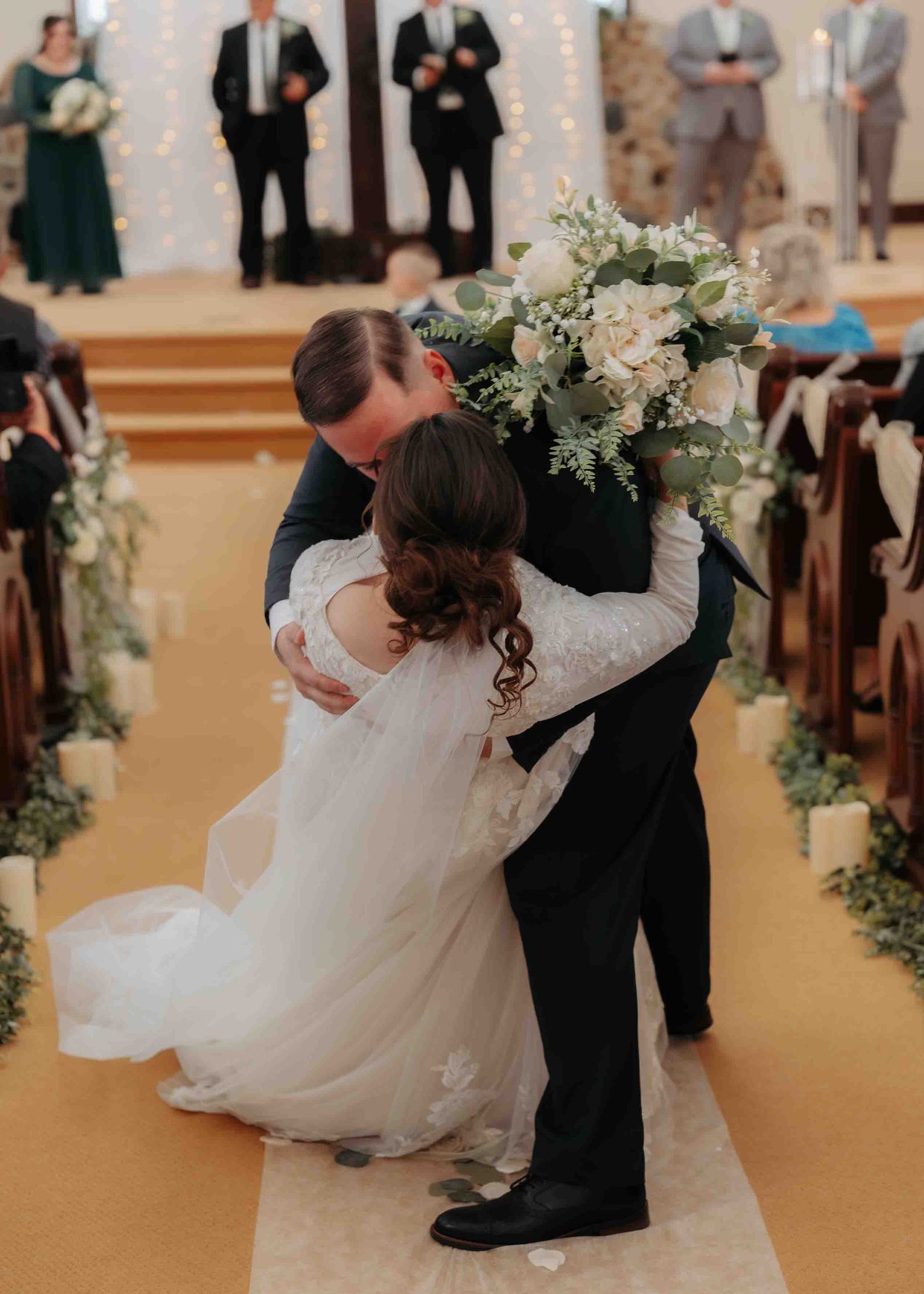 Bride and groom share a joyful embrace at the altar during their church wedding ceremony.
