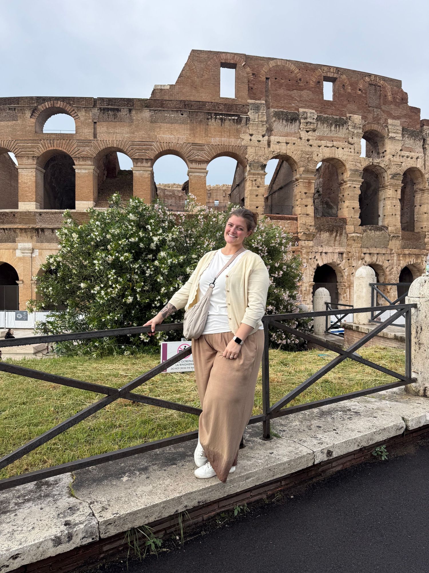 Woman posing in front of the ancient Colosseum in Rome, Italy.