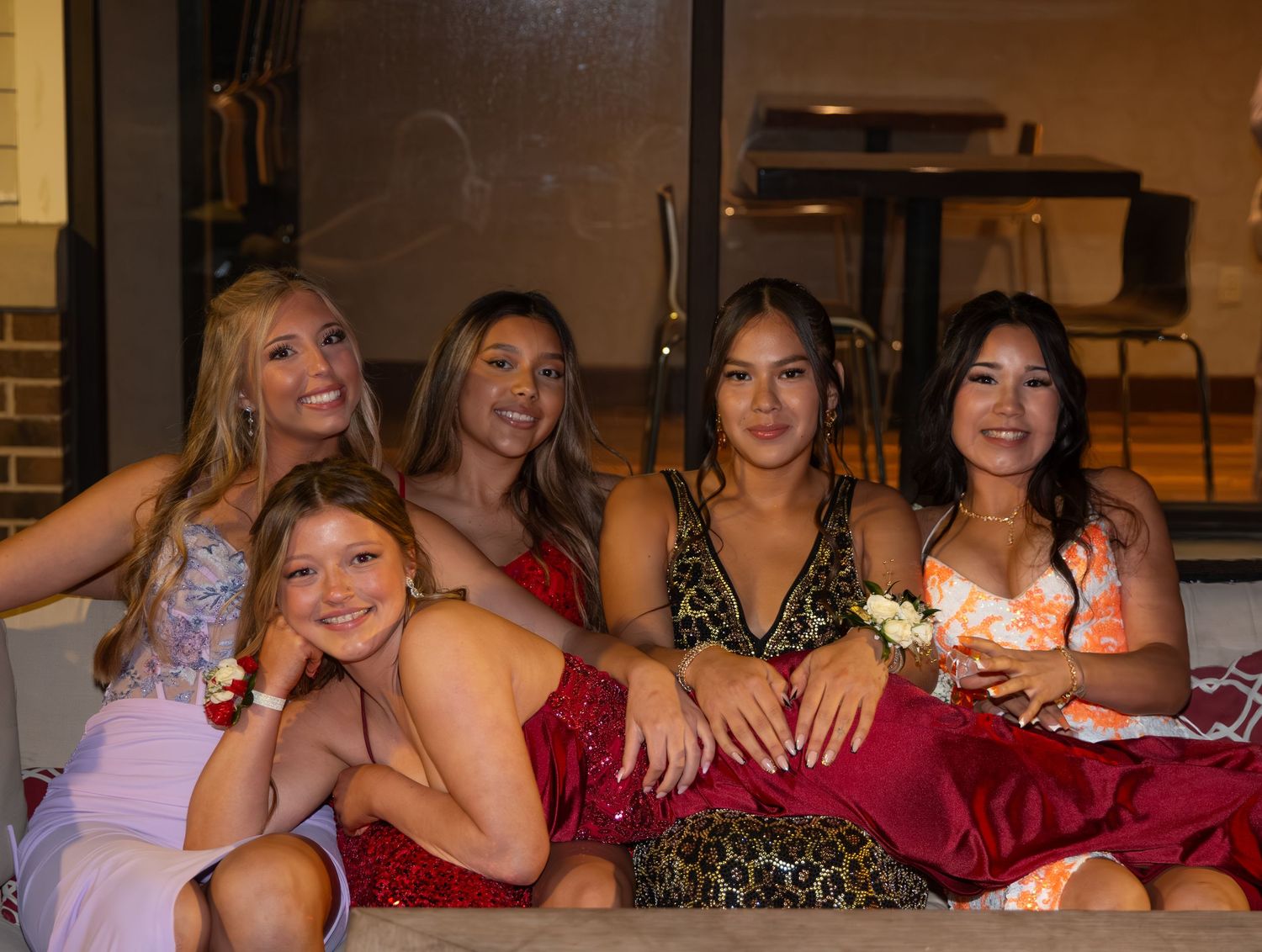 A group of girls smiling into the camera, with one lying across the others.