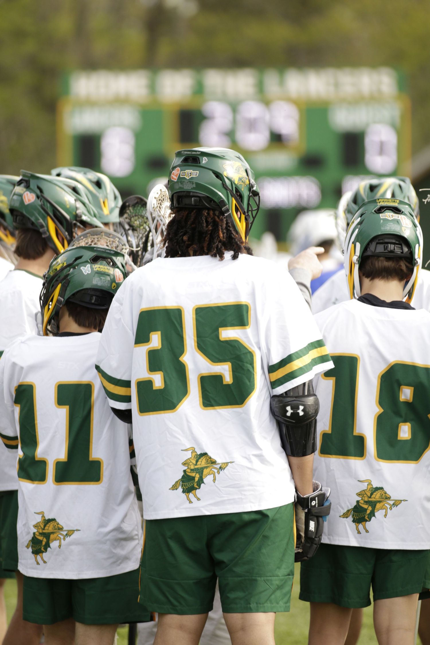 A lacrosse player was singled out from a large group of other players.