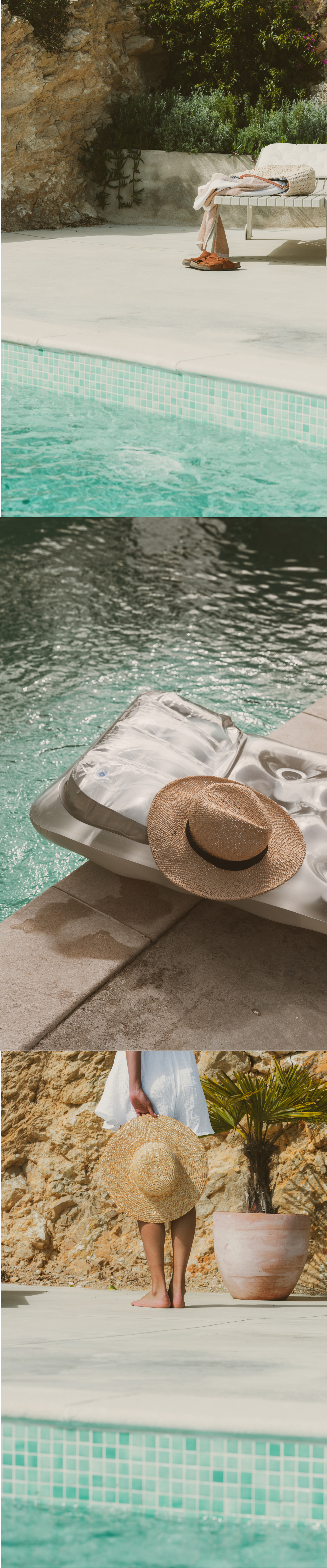 A serene poolside retreat featuring turquoise water, a straw hat on a lounger, and a woman in white holding a sun hat near rocky cliffs.