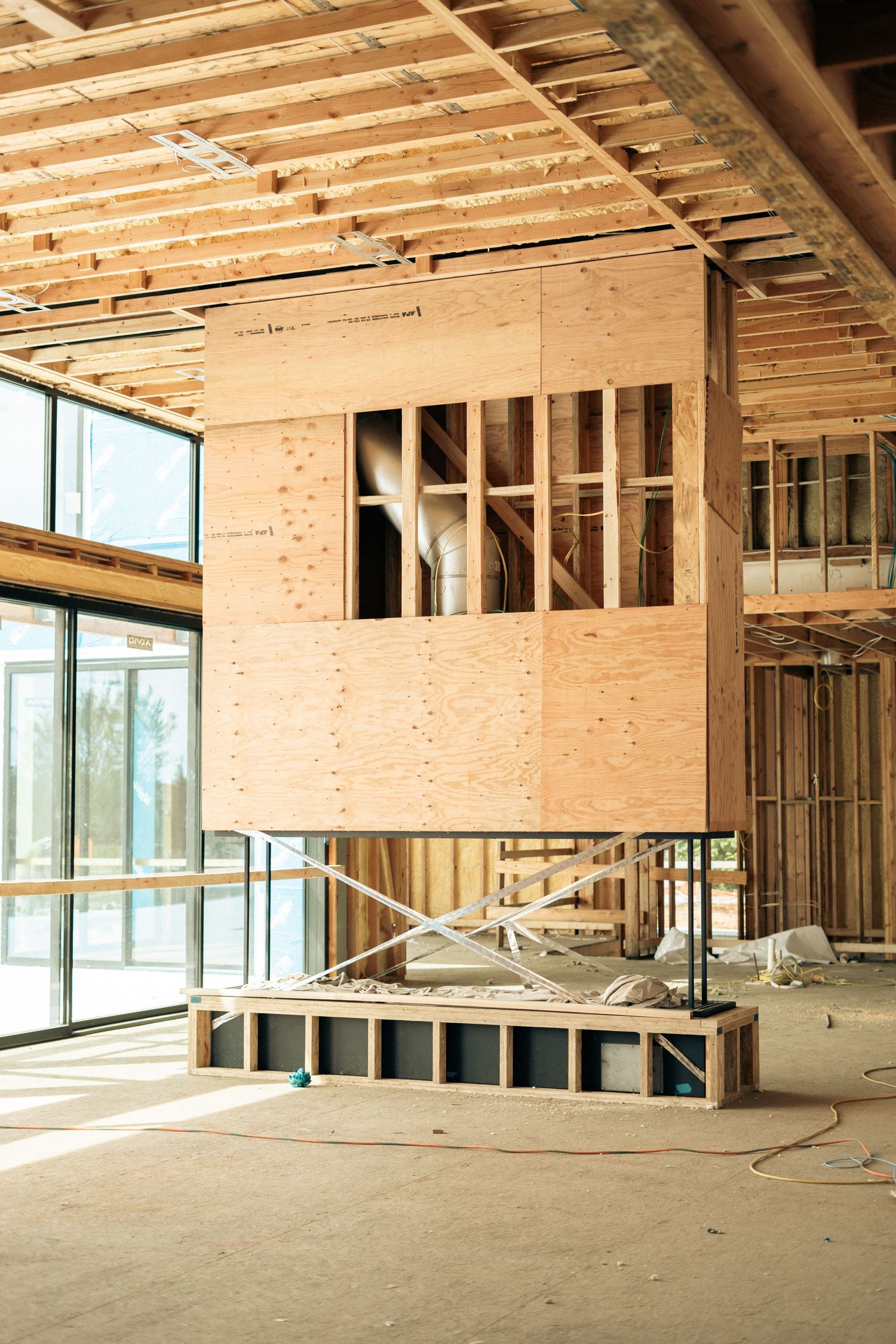 Interior of home under construction featuring a wooden box structure elevated on scaffolding.
