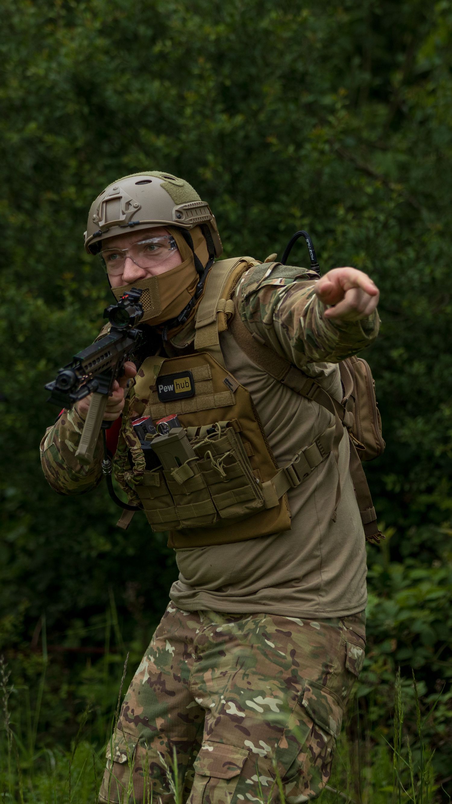 Soldier in multicam gear and helmet pointing while holding rifle during outdoor military exercise. Photo Taken by AJCoatesPhotography