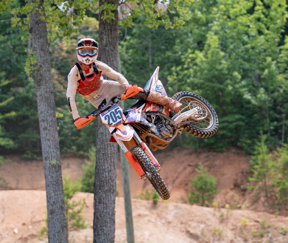 Motocross rider whipping the bike sideways while airborne.