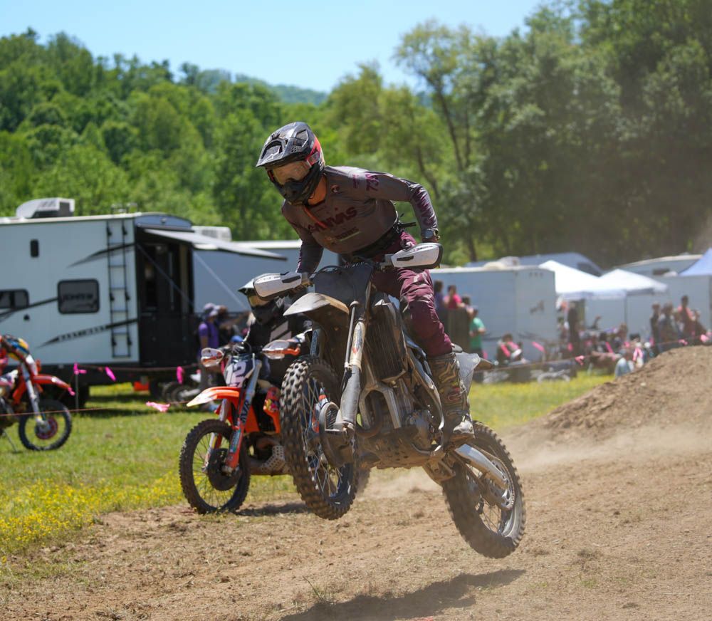 Motocross rider accelerating through a dirt course.
