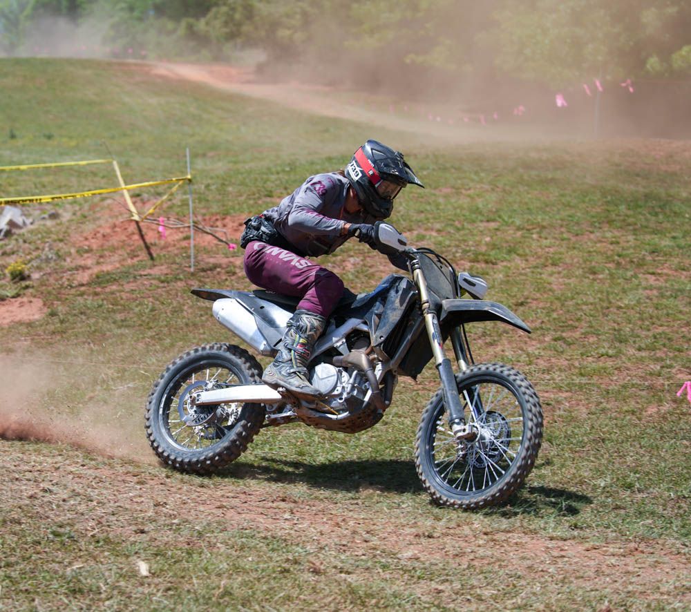Motocross rider racing through a dusty turn.