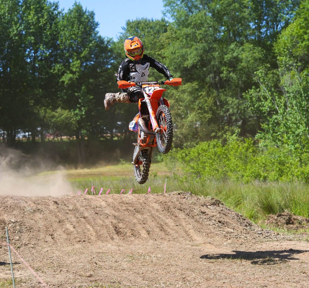 Motocross rider airborne over a dirt jump.