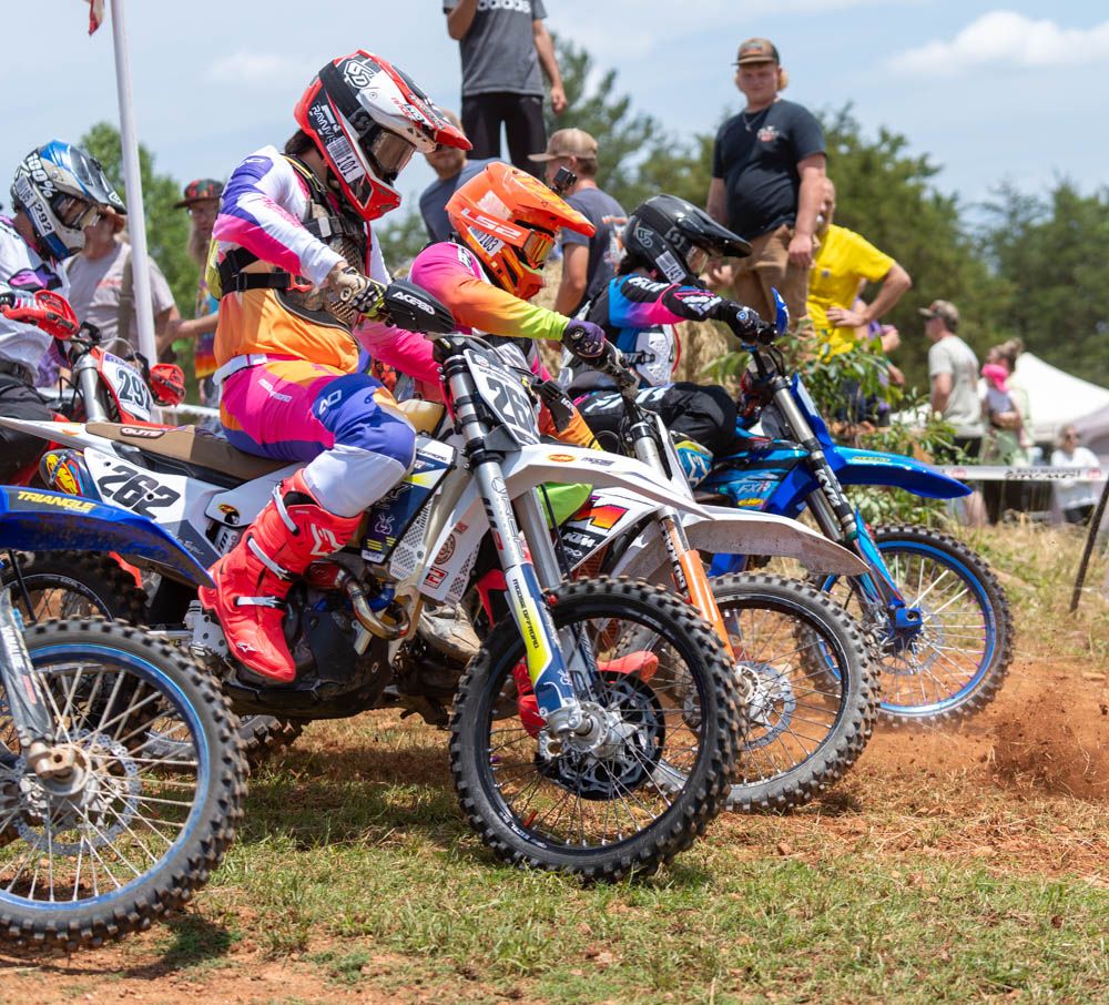Motocross riders lined up together at the start of a race.