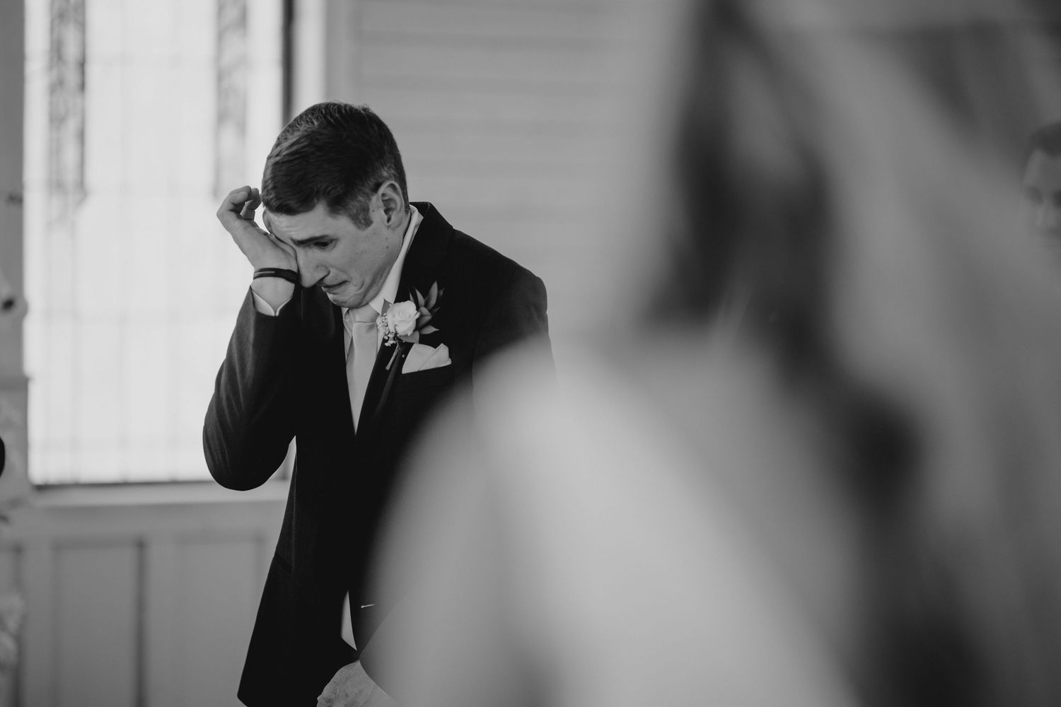 Black and white photo sequence showing a person in a suit covering their face with their hands.