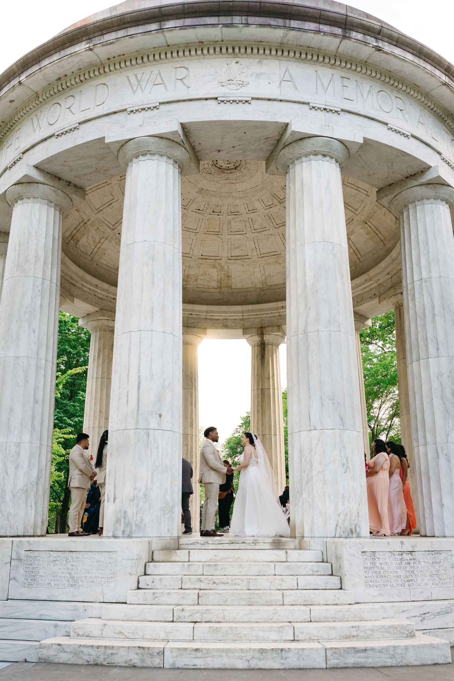 Wedding ceremony at the DC WWI Memorial with marble columns and steps.