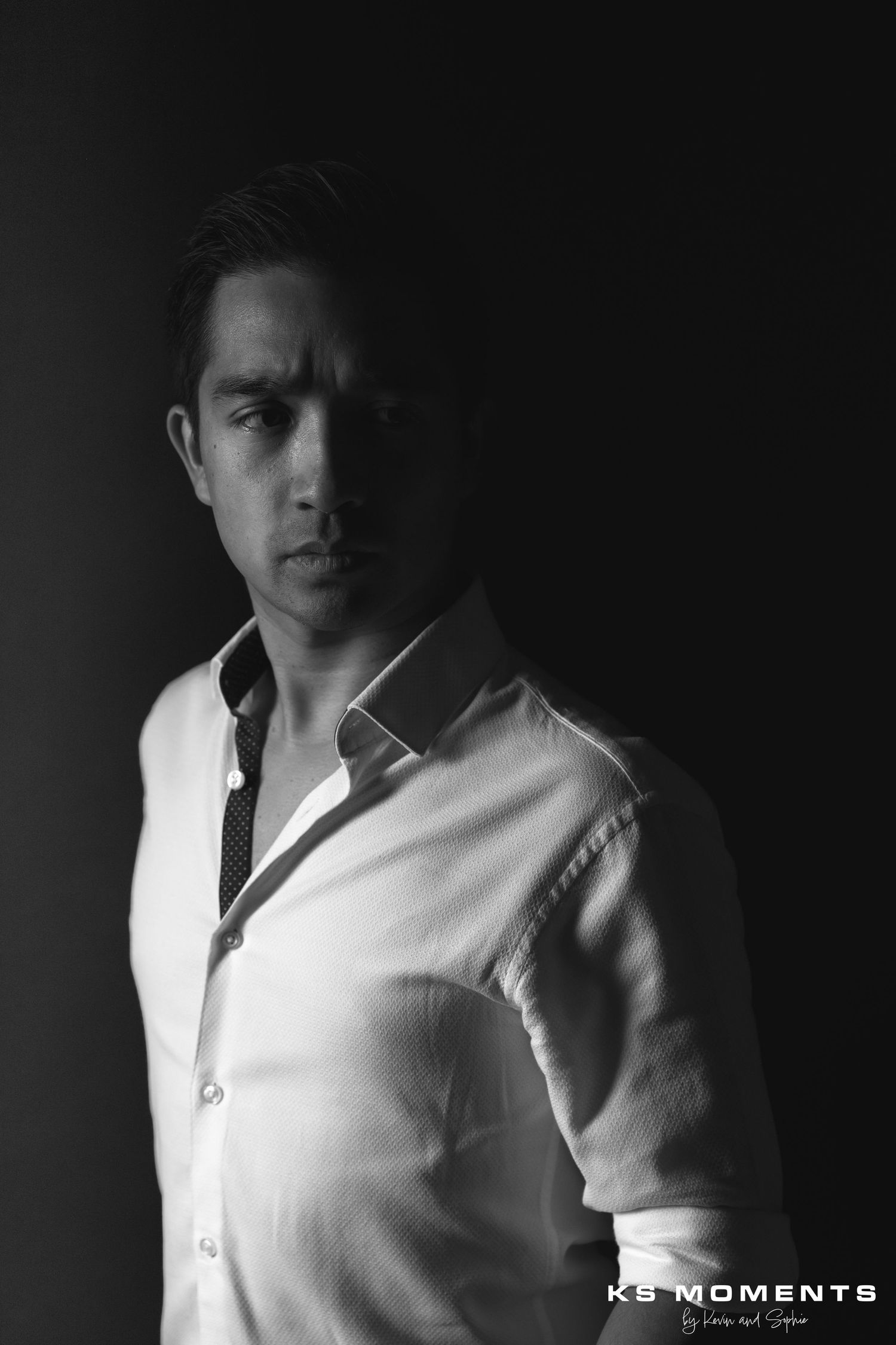 Photo d'un homme avec un regard méchant dans un studio photo avec un fond noir et un effet clair obscur
