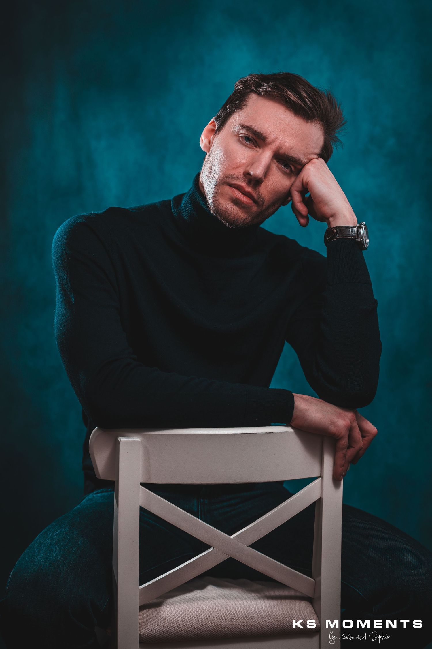 Photo d'un homme confiant assis sur une chaise dans un studio photo avec un fond bleue