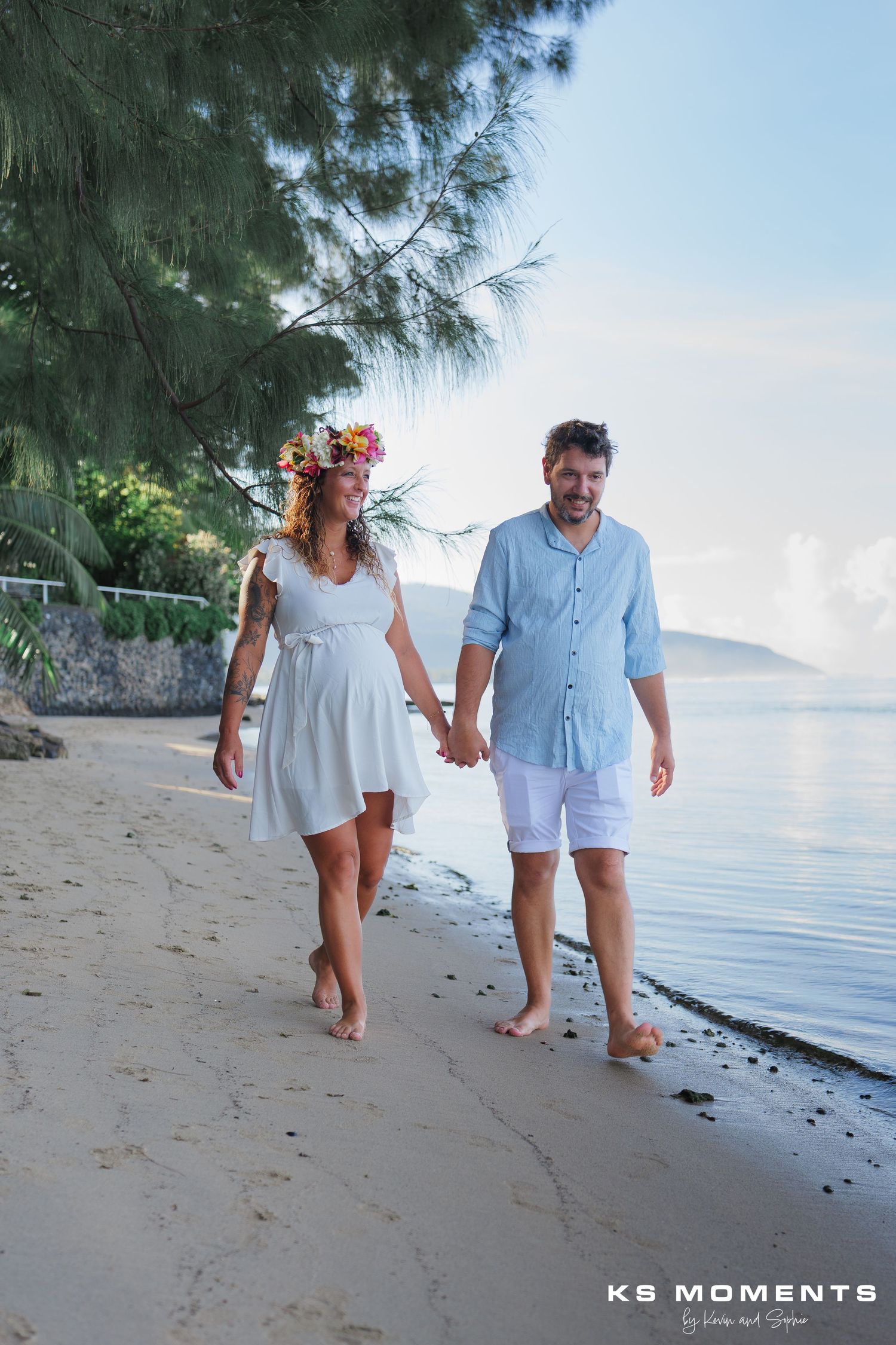 Photo d'un couple avec un femme enceinte marchant sur une plage