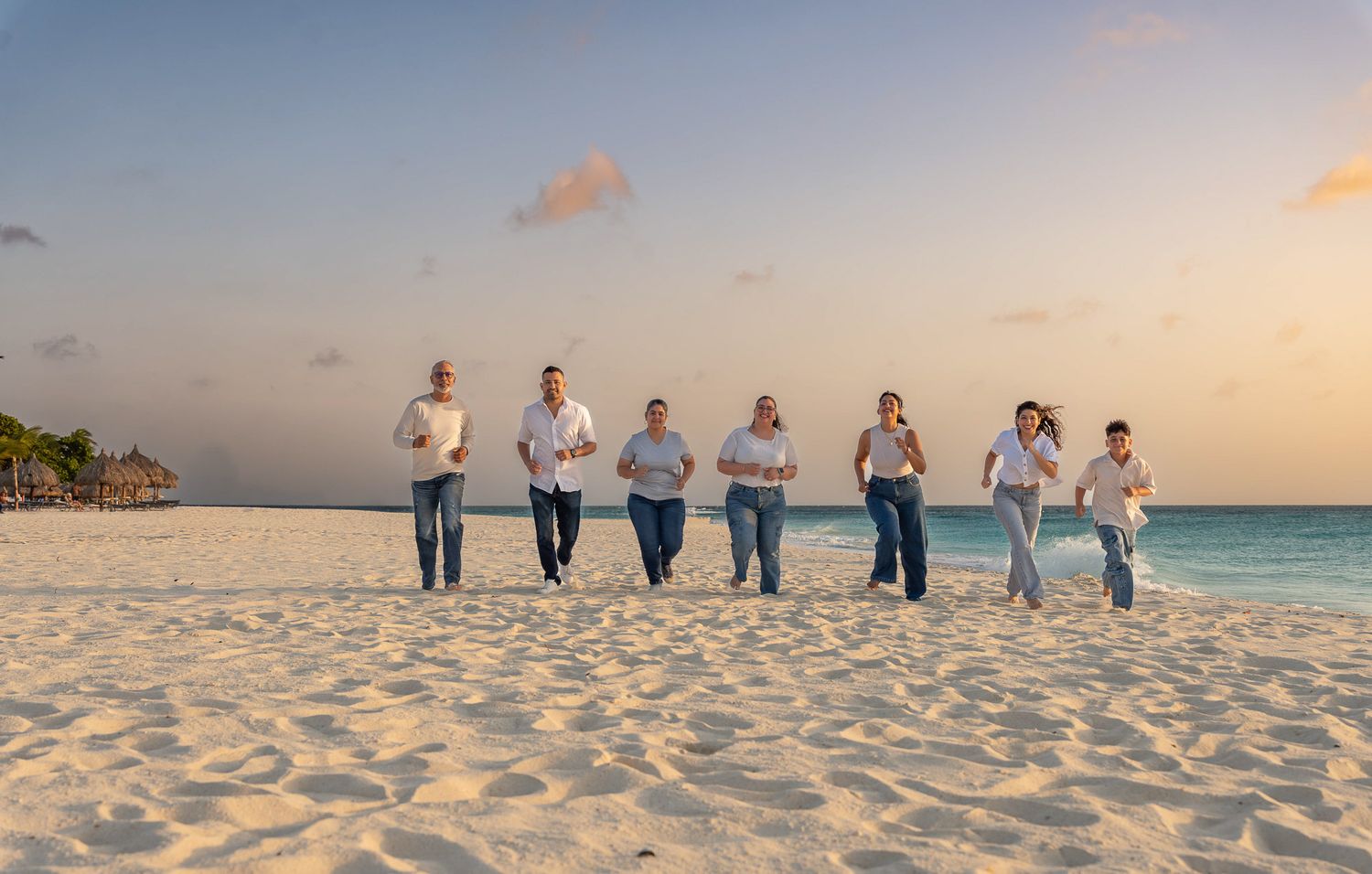 Extended family walking together along an Aruba beach at sunset, group family photoshoot