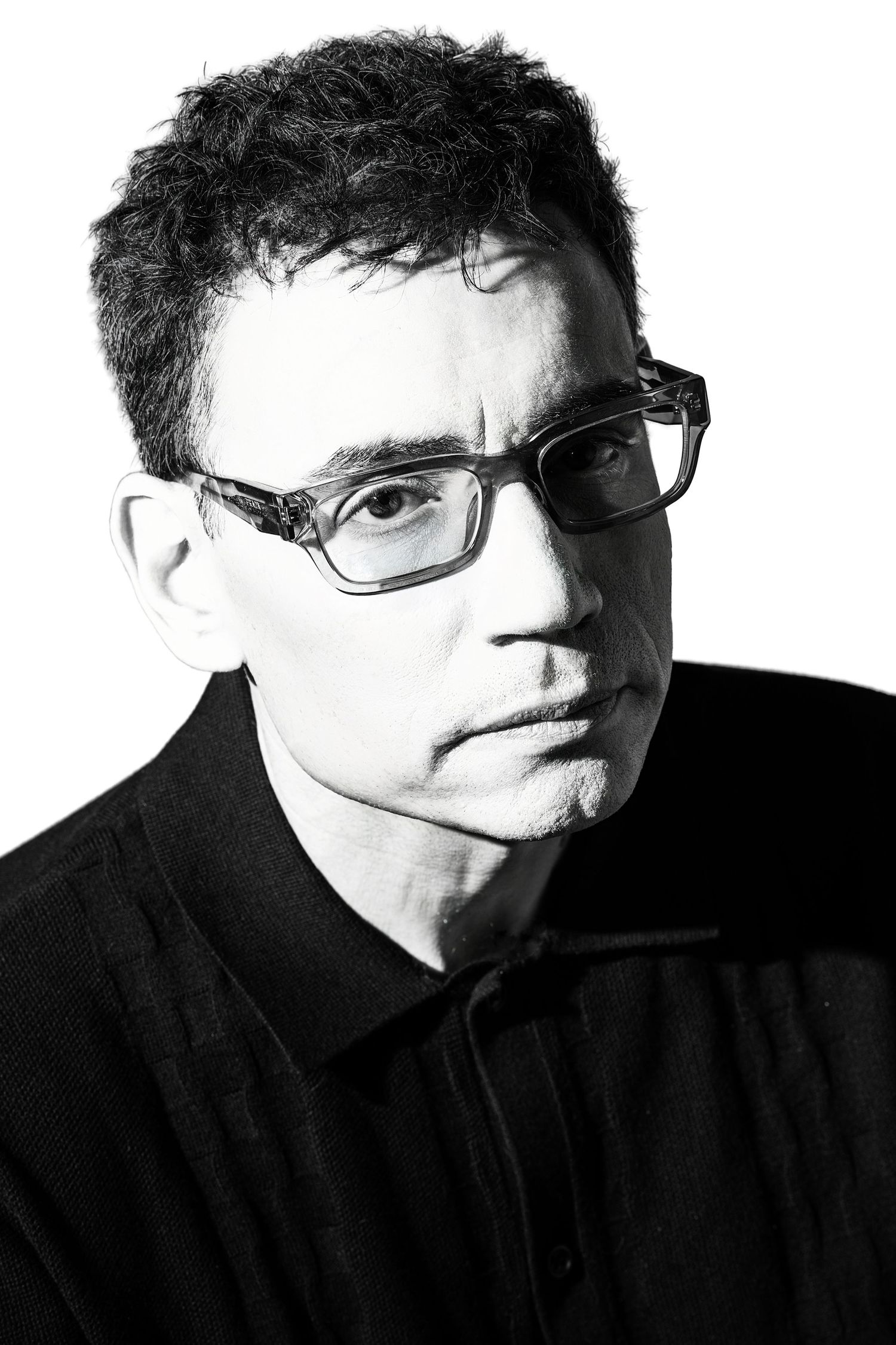 Black and white close-up portrait of a middle-aged man with glasses wearing a black shirt.  Douglas Country Colorado Artist Headshot
