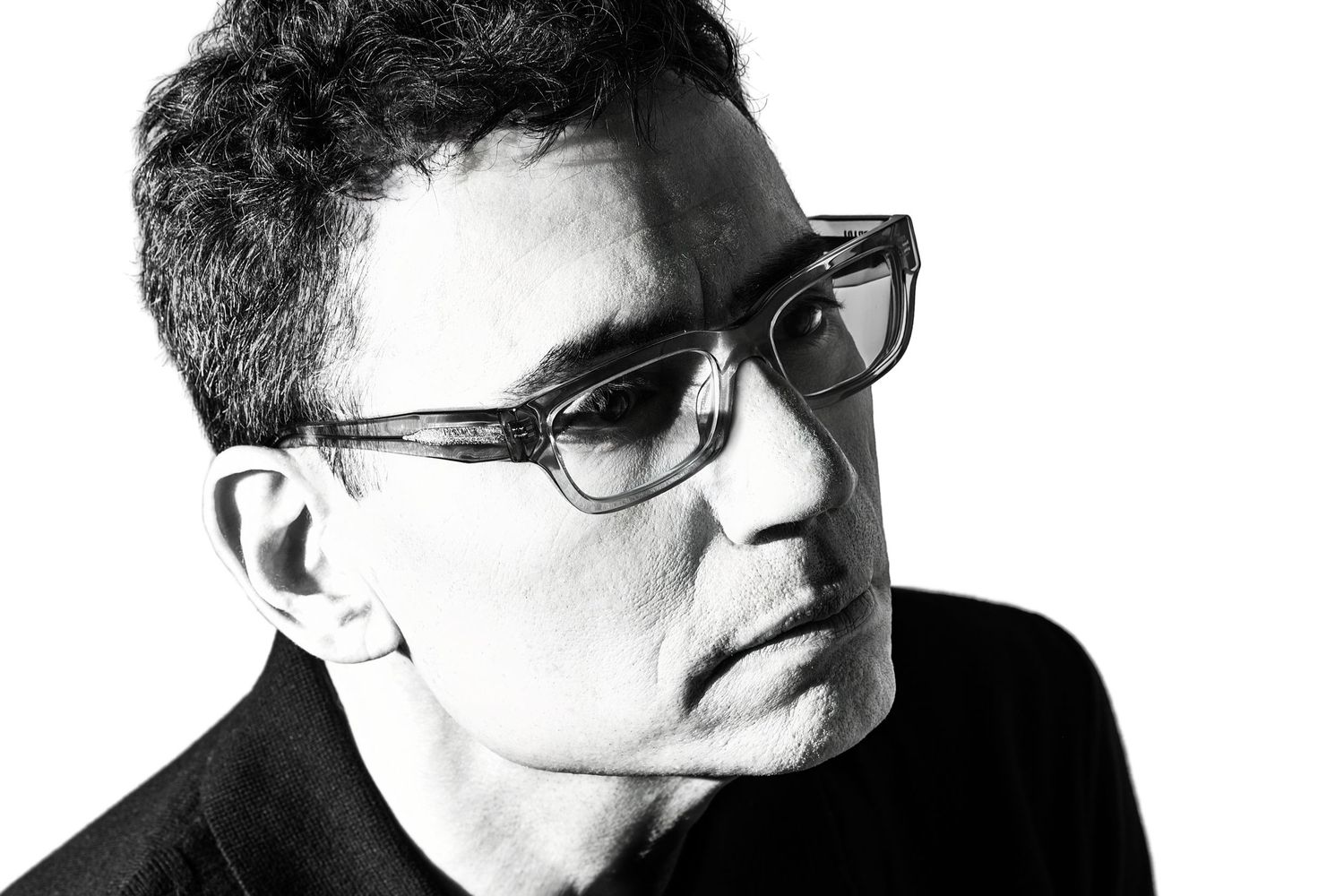 Black and white side profile portrait of a man with curly hair and rectangular glasses. Parker Colorado Artist Headshot