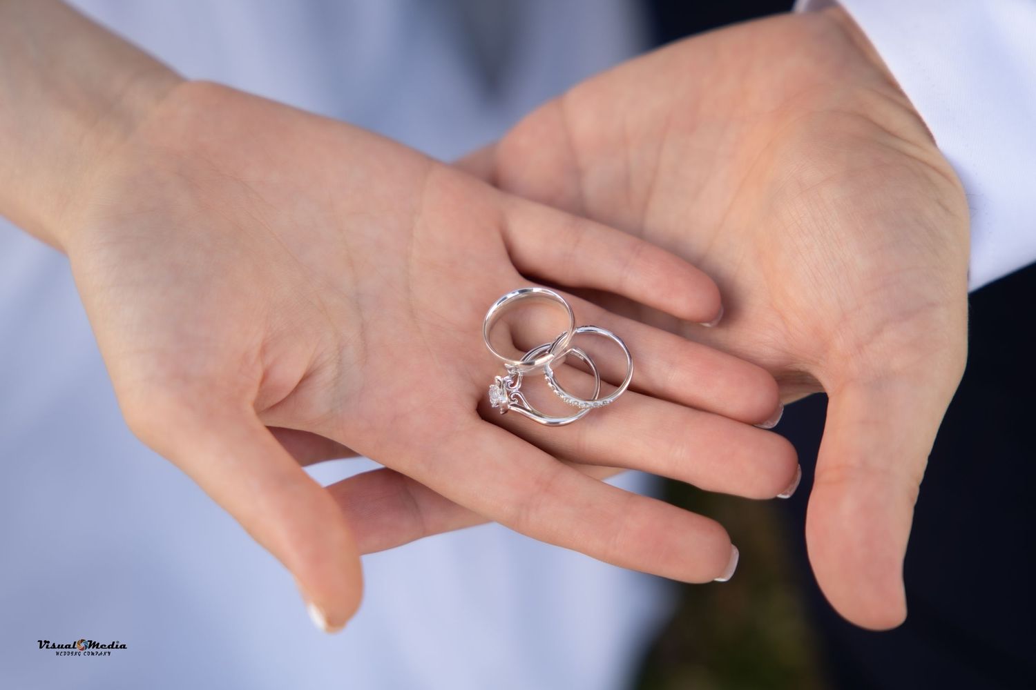 Two hands display elegant silver wedding rings, symbolizing a couple's commitment on their special day.