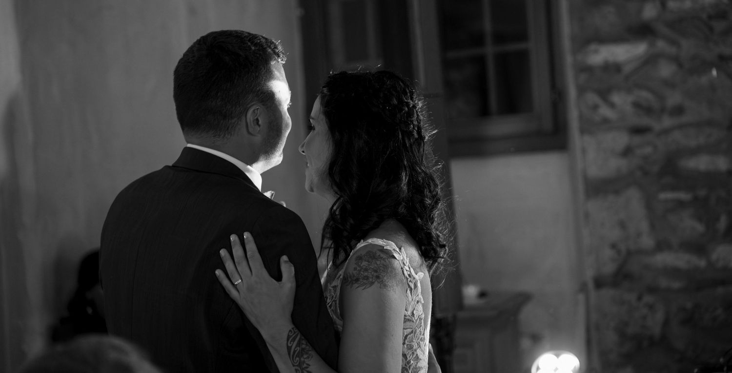 Candid black and white portrait of a bride and groom during their first dance during an intimate wedding celebration in Valais.