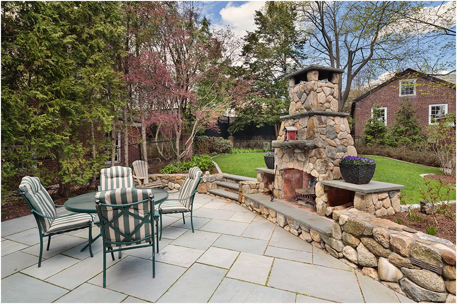 Architectural photograph of Boston home renovations in Newton, showing exterior fireplace design and build around patio space.
