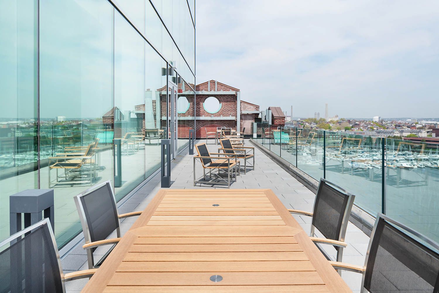 Converse Boston HQ top deck architectural image with views over the harbor and seating area on the balcony.