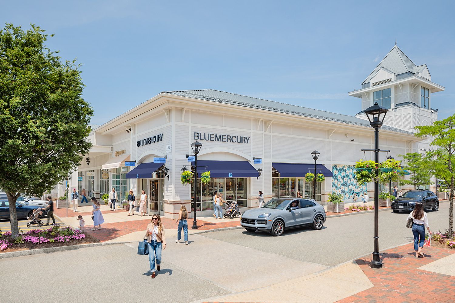 ARCHITECTURAL DETAIL PHOTOGRAPHY OF NEW ENGLAND MALL DURING THE SUMMER WITH PERSON CROSSING THE ROAD IN FRONT OF SHOPS