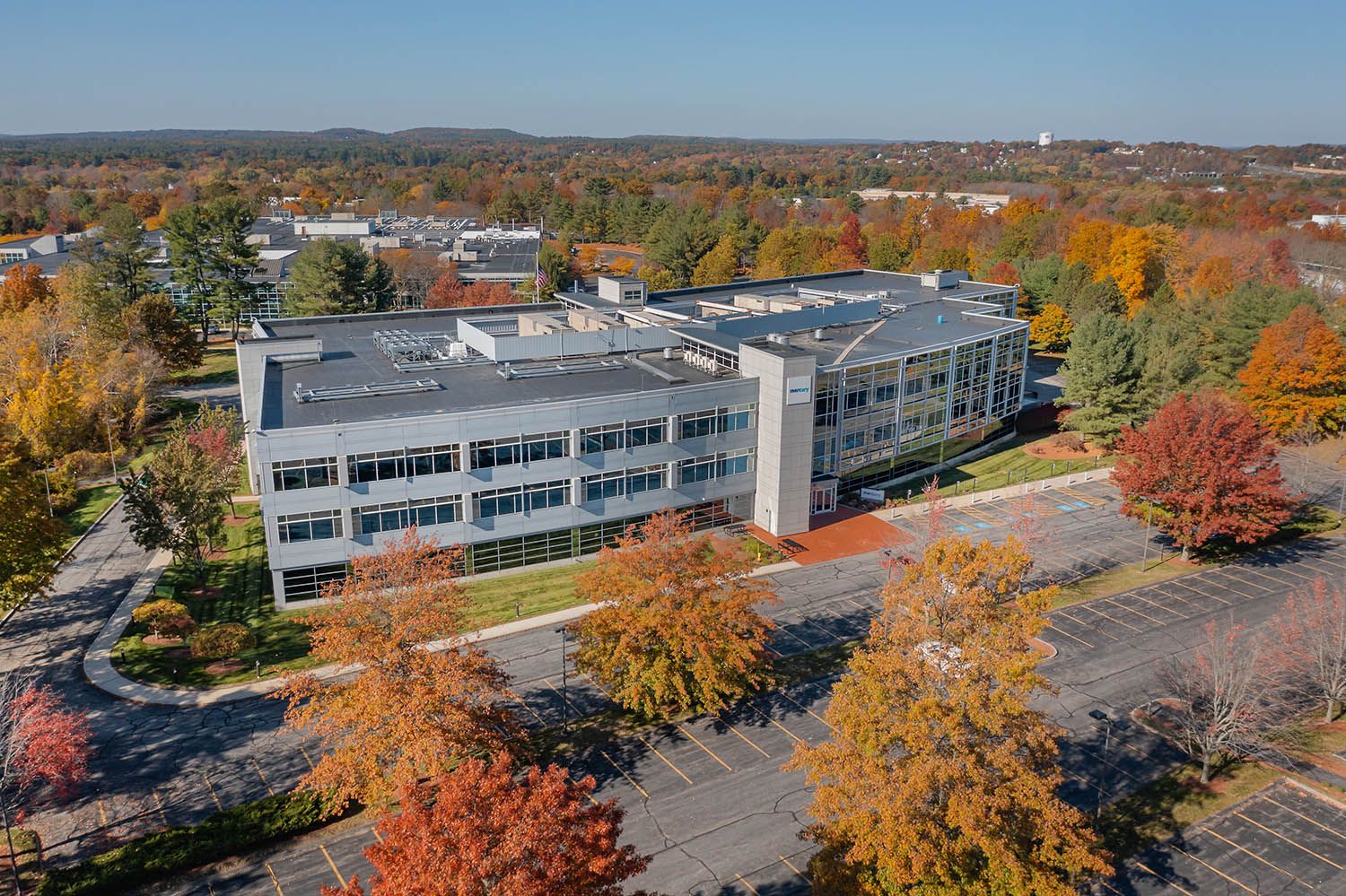 Architectural Drone image of office building taken during the fall to showcase it's location for commercial real estate purposes.