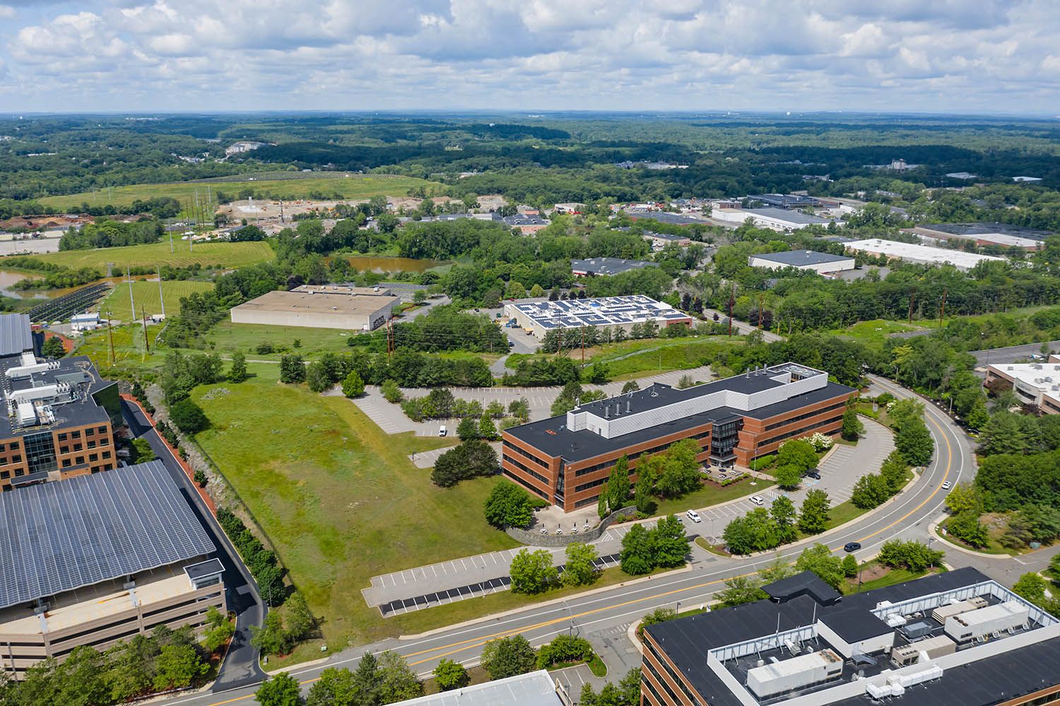 Architectural aerial photograph of office location near to Boston MA on a sunny summer day showcasing the green space around location.