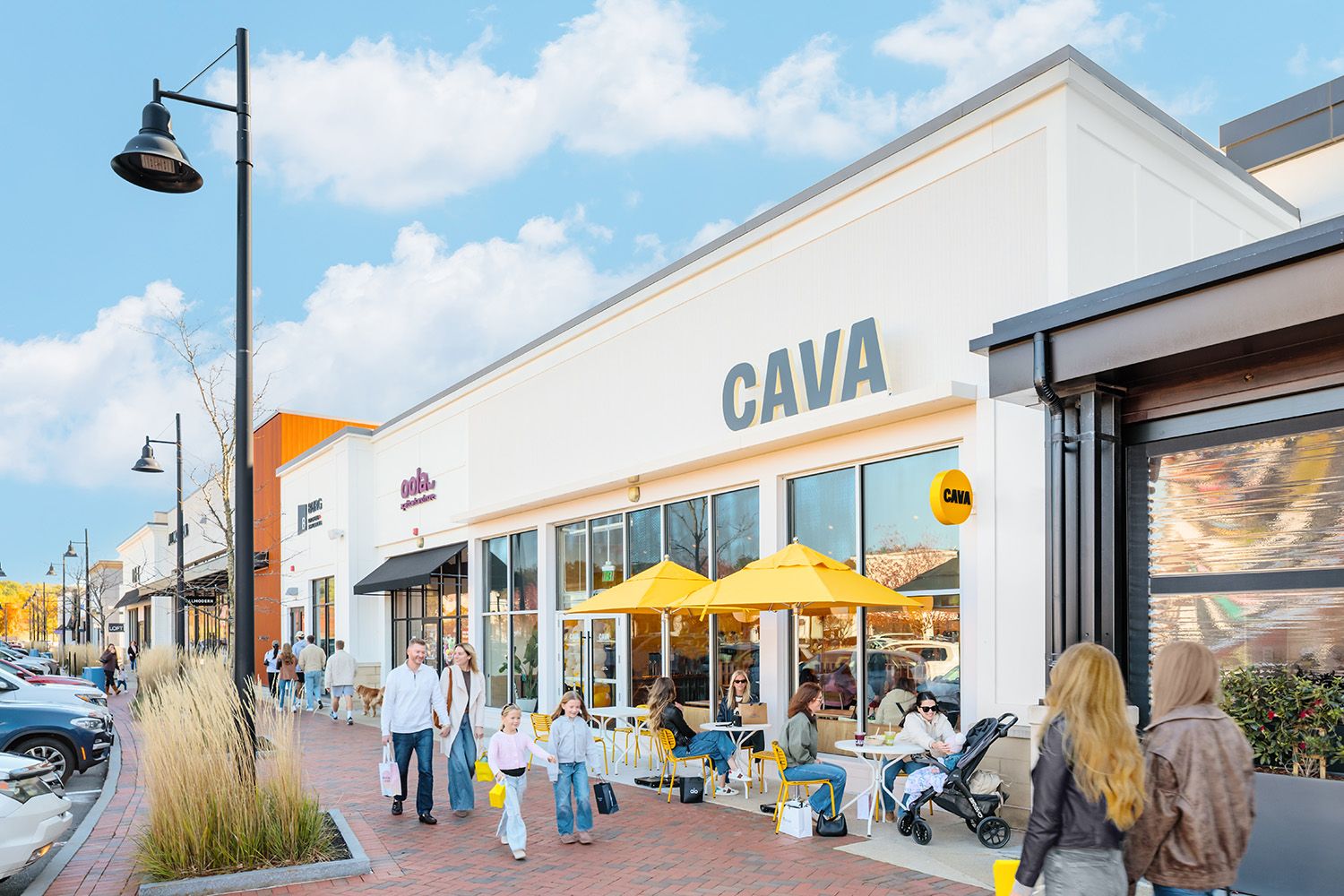 ARCHITECTURAL RETAIL PHOTOGRAPH IN BOSTON WITH PEOPLE SITTING OUTSIDE RESTAURANT AND WALKING PAST TO GO TO SHOPS