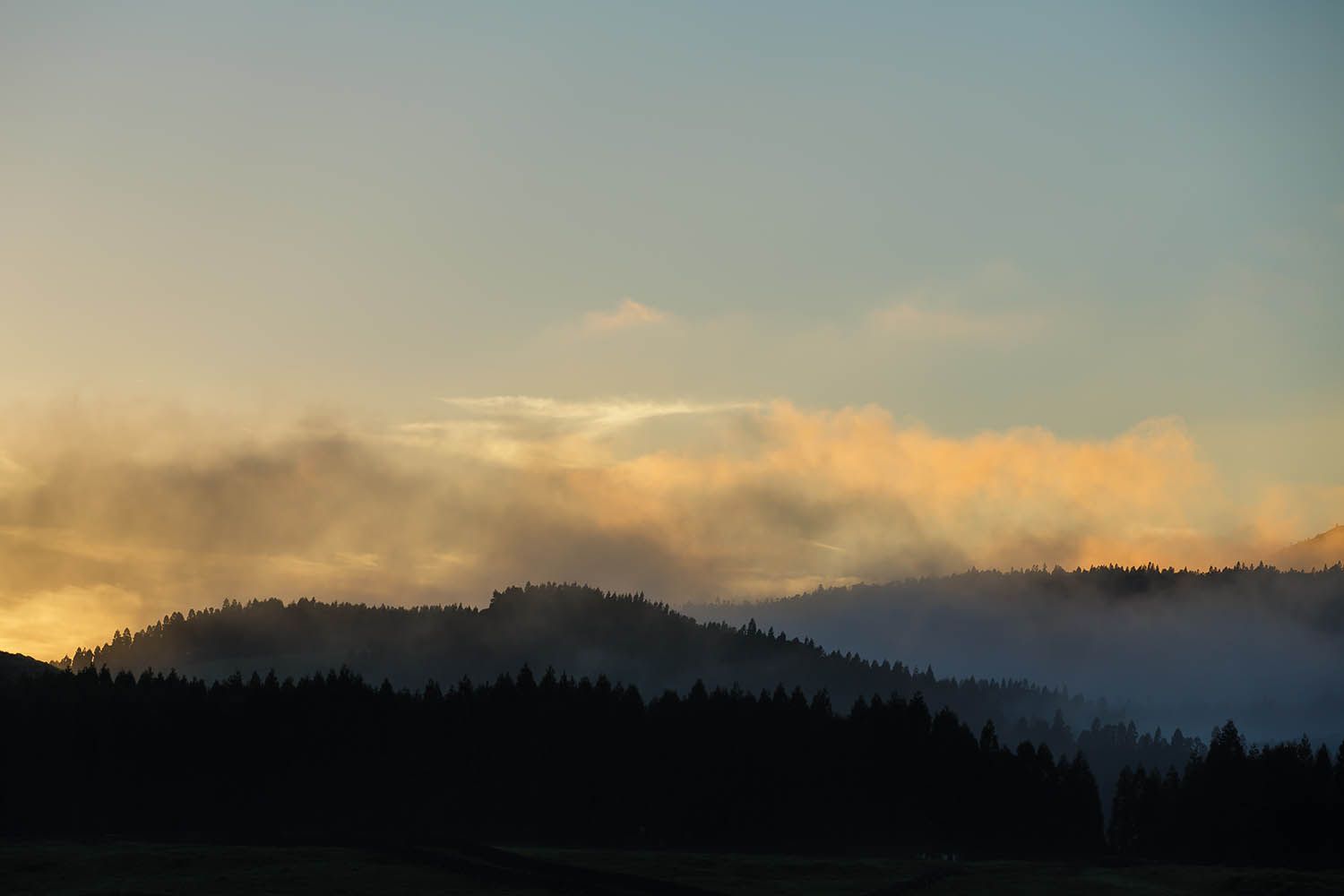 Color landscape photograph of Terceira Island in the Azores Portugal, showing sunset in the hills of the interior of the island.