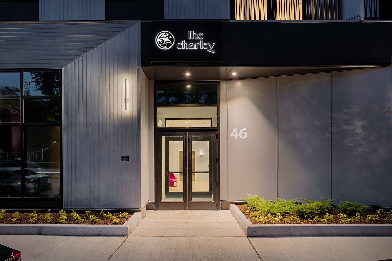 ENTRANCE WAY TO NEW BOSTON RESIDENTIAL COMPLEX WITH THE IMAGE TAKEN AT NIGHT TO SHOWCASE THE ARCHITECTURAL LIGHTING FIXTURES