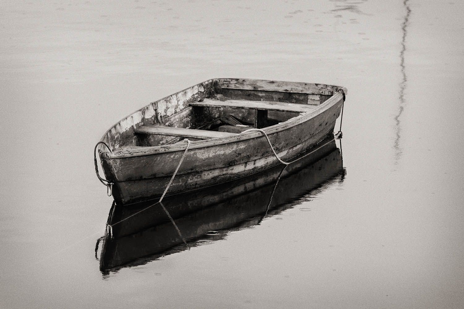 BLACK AND WHITE LANDSCAPE PHOTO OF OLD BOAT IN THW WATER IN MAINE NEW ENGLAND