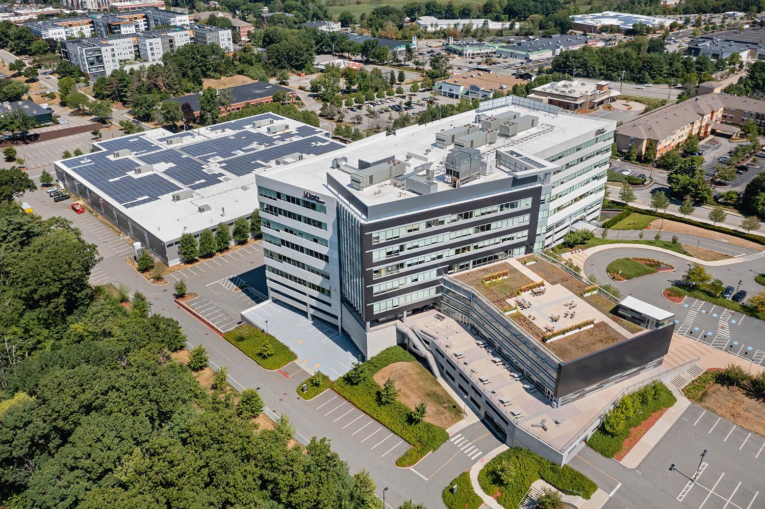 Architectural Drone image of office facility in Burlington MA to show the building, parking facilities and roof deck and transport links