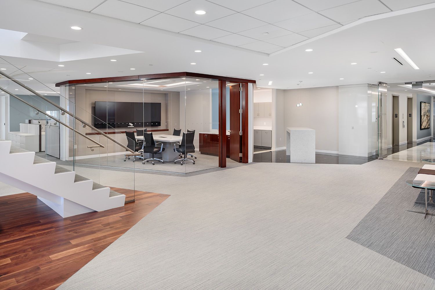 A VIEW OF STAIRCASE HEADING TO AN UPPER FLOOR AND A GLASS WALL MEETING ROOM FEATURING IN THE BACKGROUND