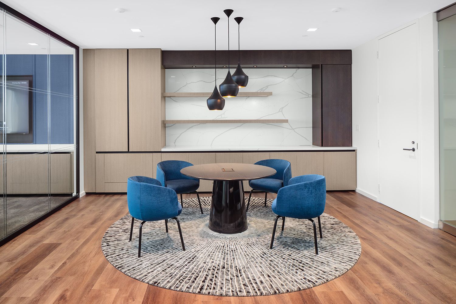 THE LOBBY SPACE OF A BOSTON AREA LAW FIRM WITH ARCHITECTURAL LIGHTING INSTALLED OVER TABLE AND CHAIRS