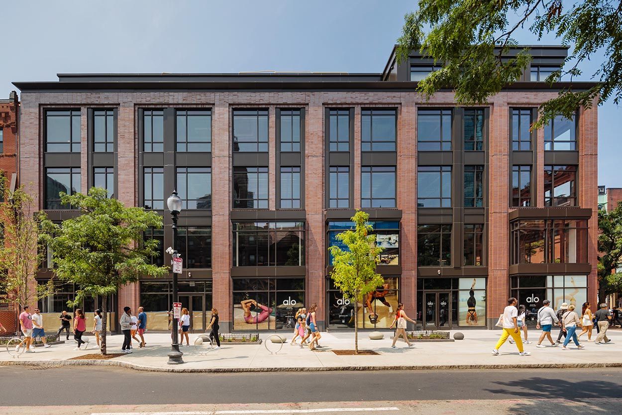 Architectural image of new building on Newbury St, mixed used office and retail space with people moving freely on the street and sunny day