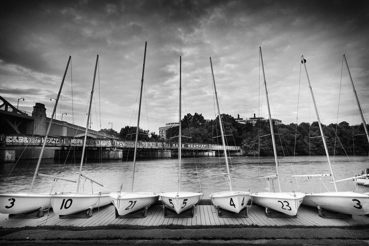 BLACK AND WHITE LANDSCAPE PHOTO OF BOATS ALONG THE CHARLES RIVER IN BOSTON MASSACHUSETTS