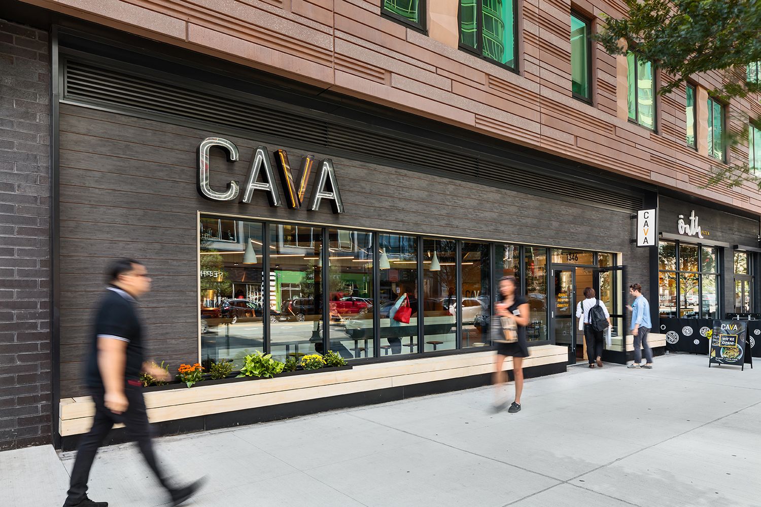 BOSTON ARCHITECTURAL PHOTOGRAPHERS IMAGE OF CAVA RESTAURANT IN THE CITY WITH PEOPLE WALKING PAST AND ENTERING THE BUILDING FOR ARCHITECTS