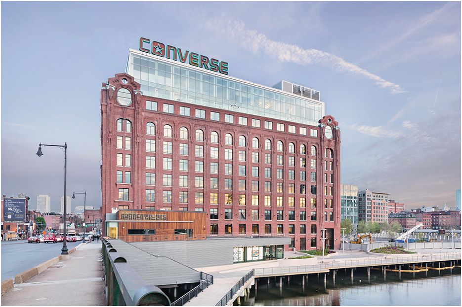 Architectural photograph of Bostons Converse headquarters exterior image, showing the main building taken at dusk with Boston in background