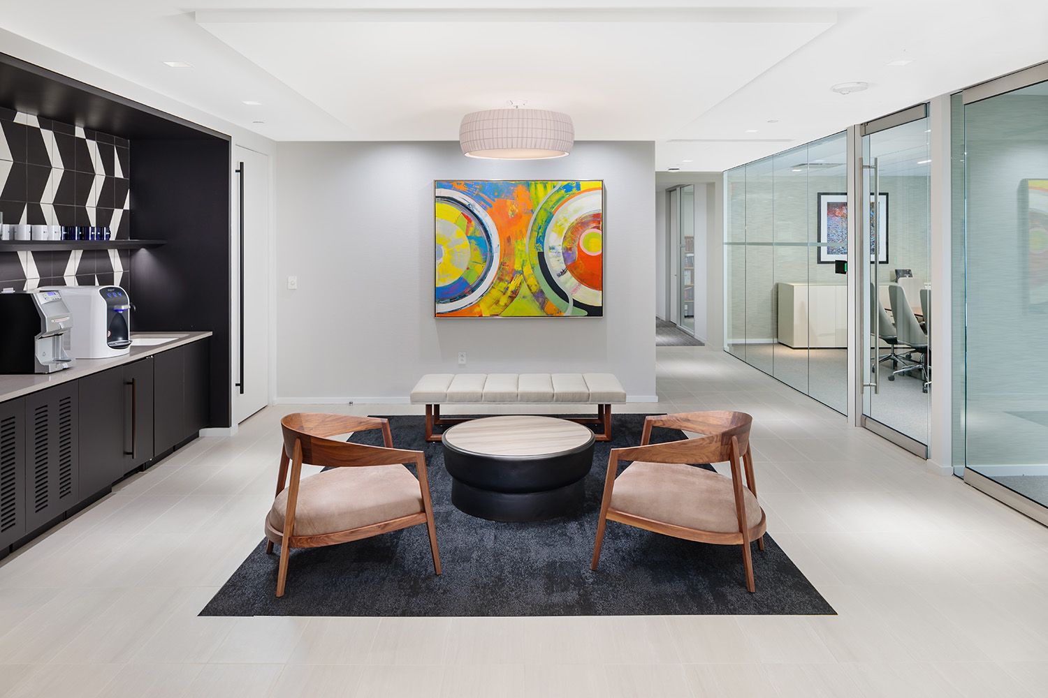 A WAITING AREA WITH ARTWORK AND COFFEE STATION THAT WAS DESIGNED BY A INTERIOR DESIGN COMPANY BASED IN BOSTON MA