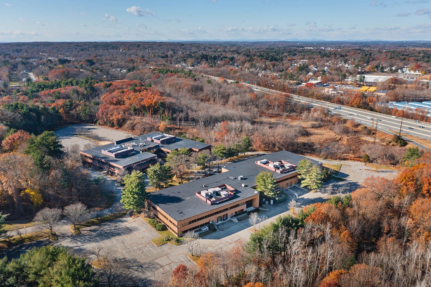 Architectural Drone image of office location near Boston taken during the fall with colorful leaves still on the trees.