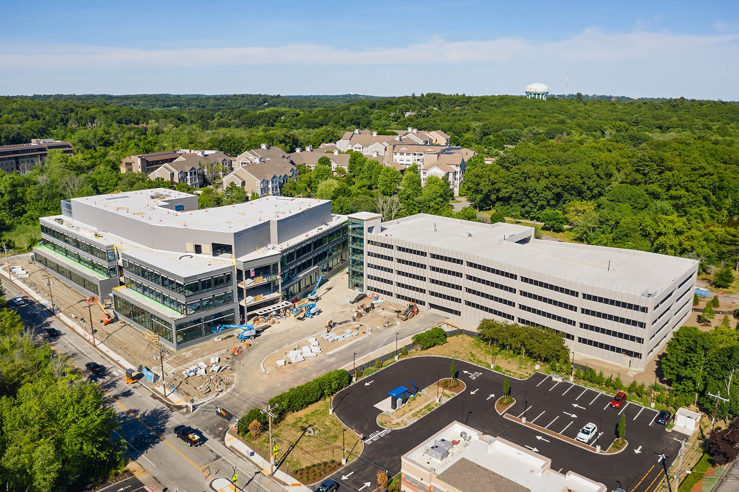 Architectural Drone image of new office development on Waltham MA showing main office building and parking structure next door on sunny day