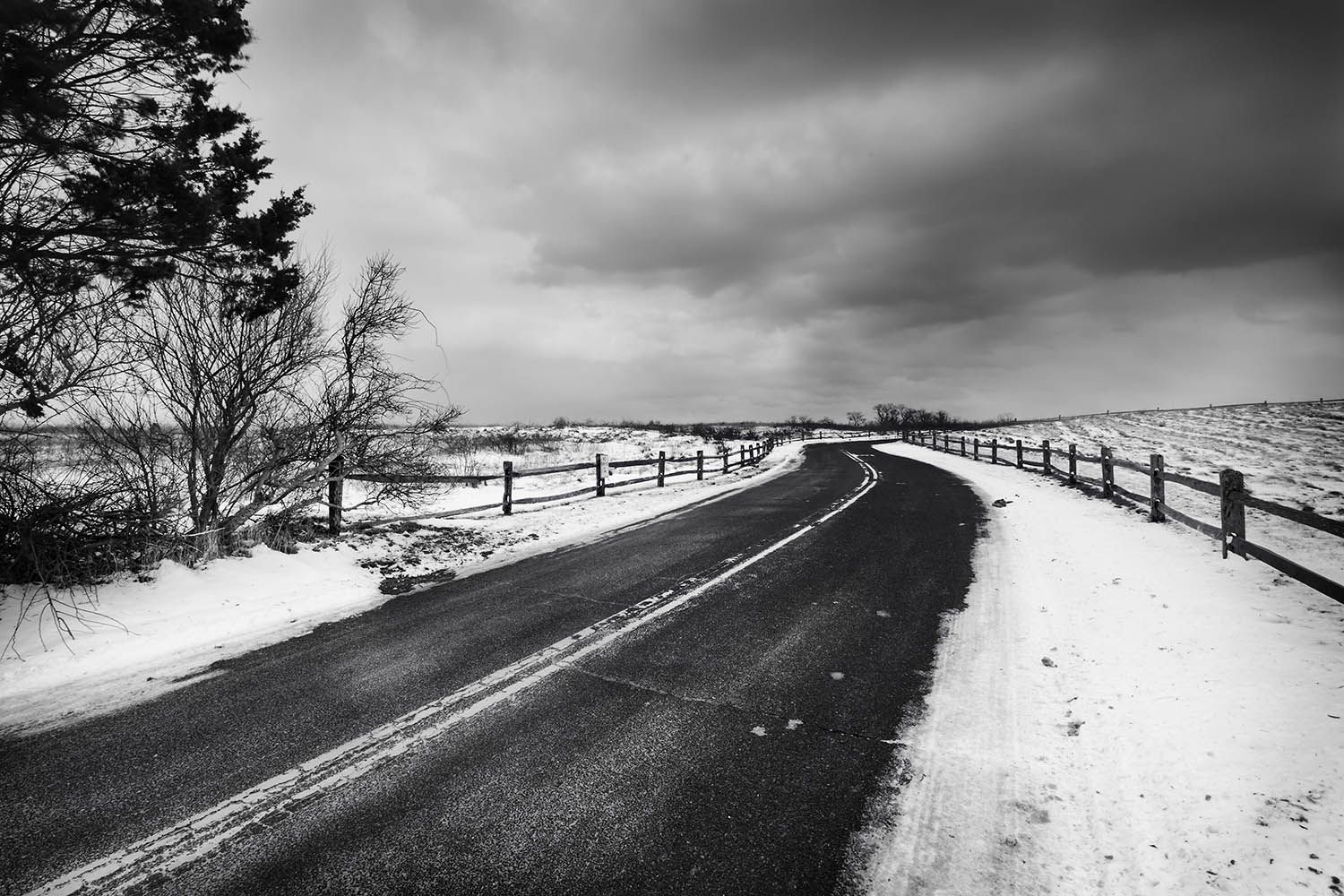 BLACK AND WHITE LANDSCAPE PHOTO OF WINTER SCENE SHOW ROAD THROUGH THE SNOW