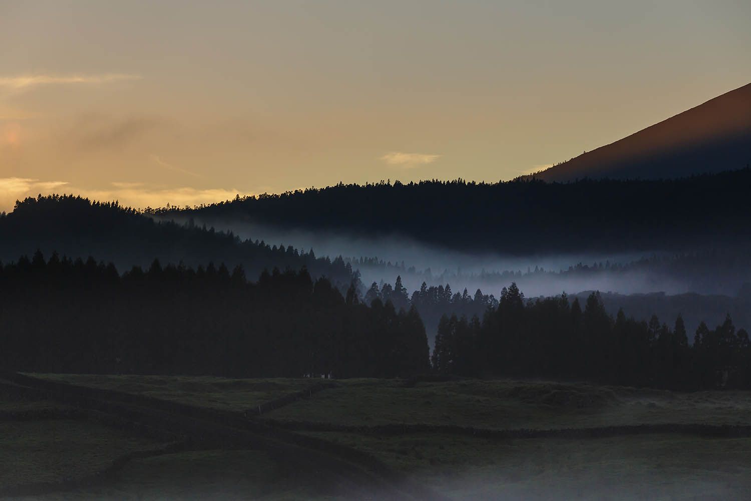 Color landscape photograph of Terceira Island in the Azores Portugal, showing fog hanging in the valley on the interior of the island.