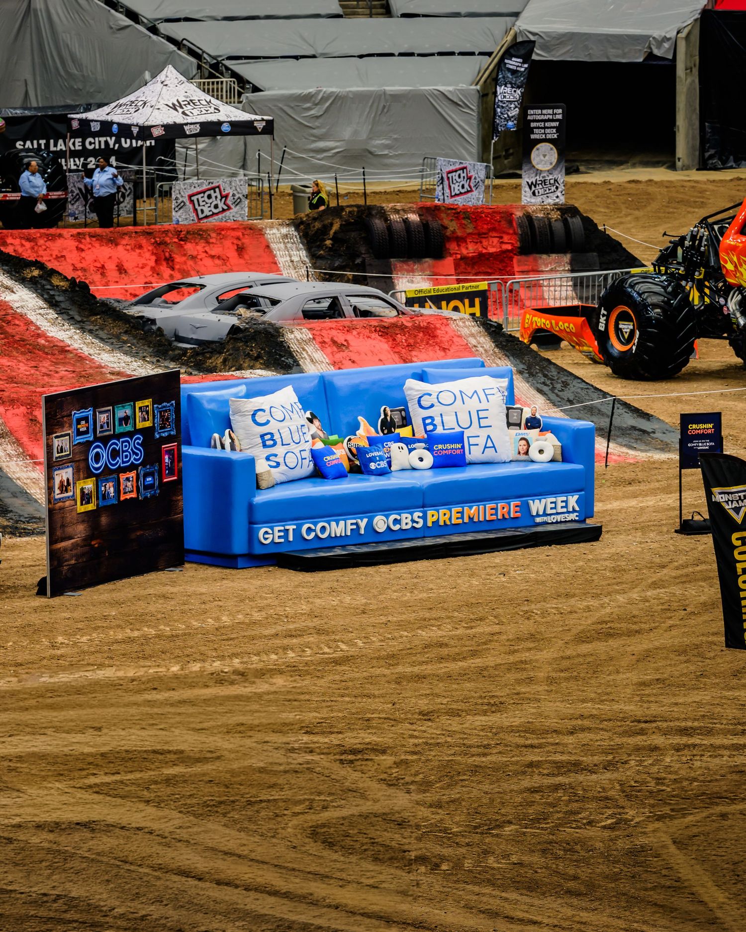 Large blue CBS promotional banners and seating areas set up on sandy ground at an outdoor event venue.