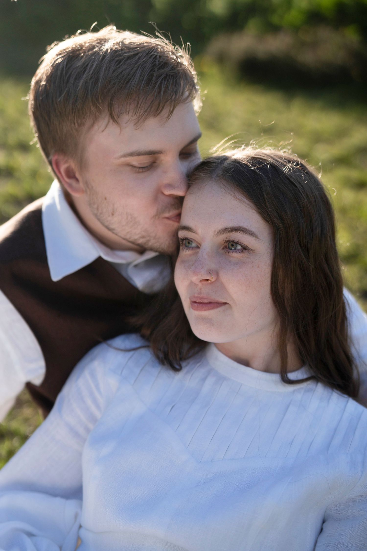 A romantic couple shares tender moments in a series of outdoor photos with soft natural lighting.
