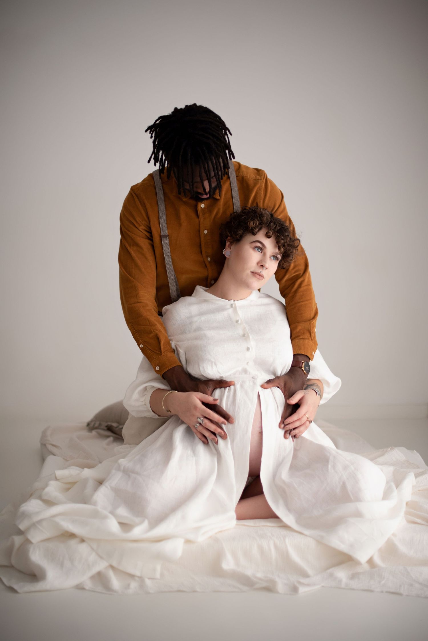A tender maternity photoshoot featuring a couple in rustic attire.